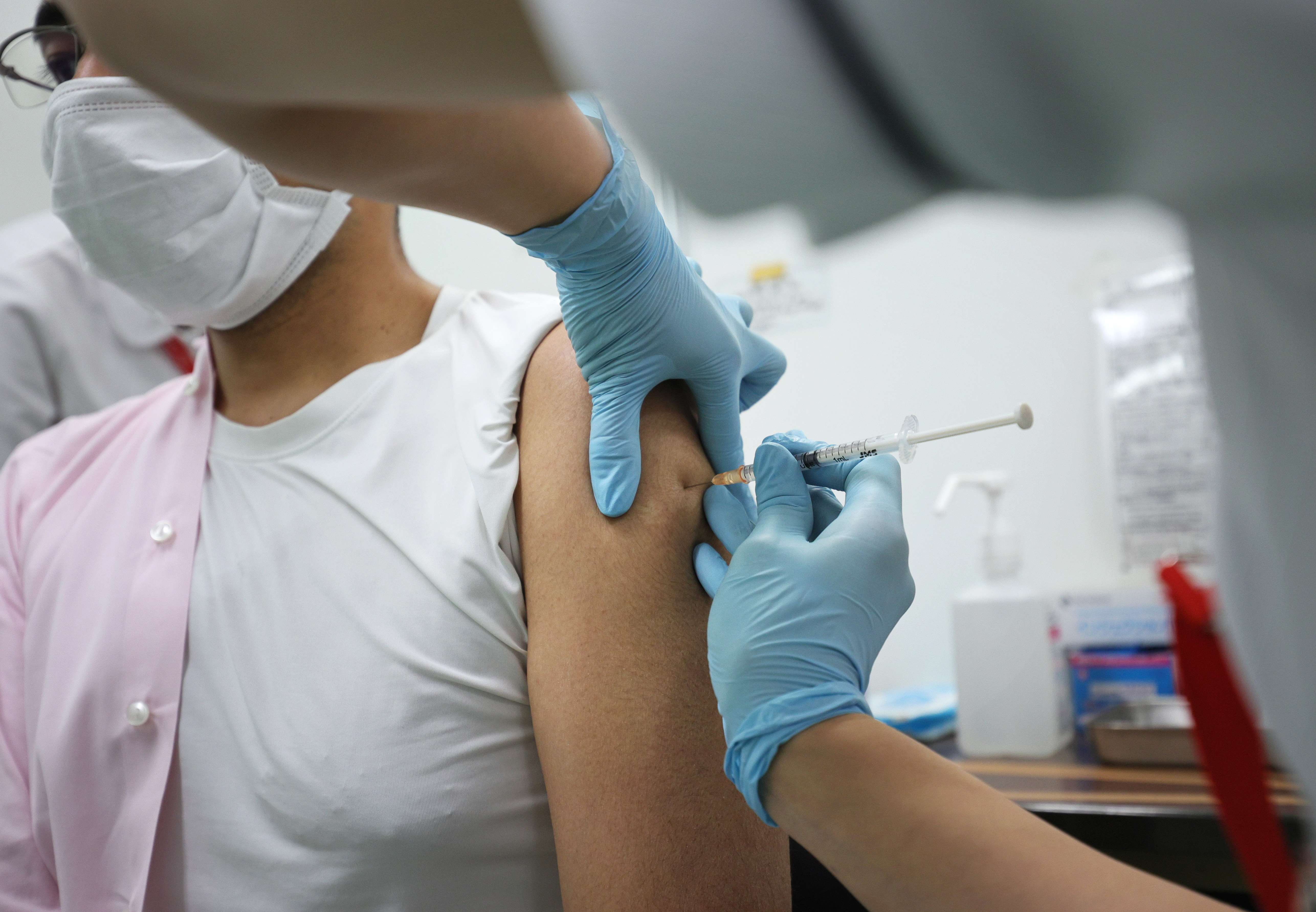 ワクチン接種を受ける男性（2021年11月、東京都千代田区）