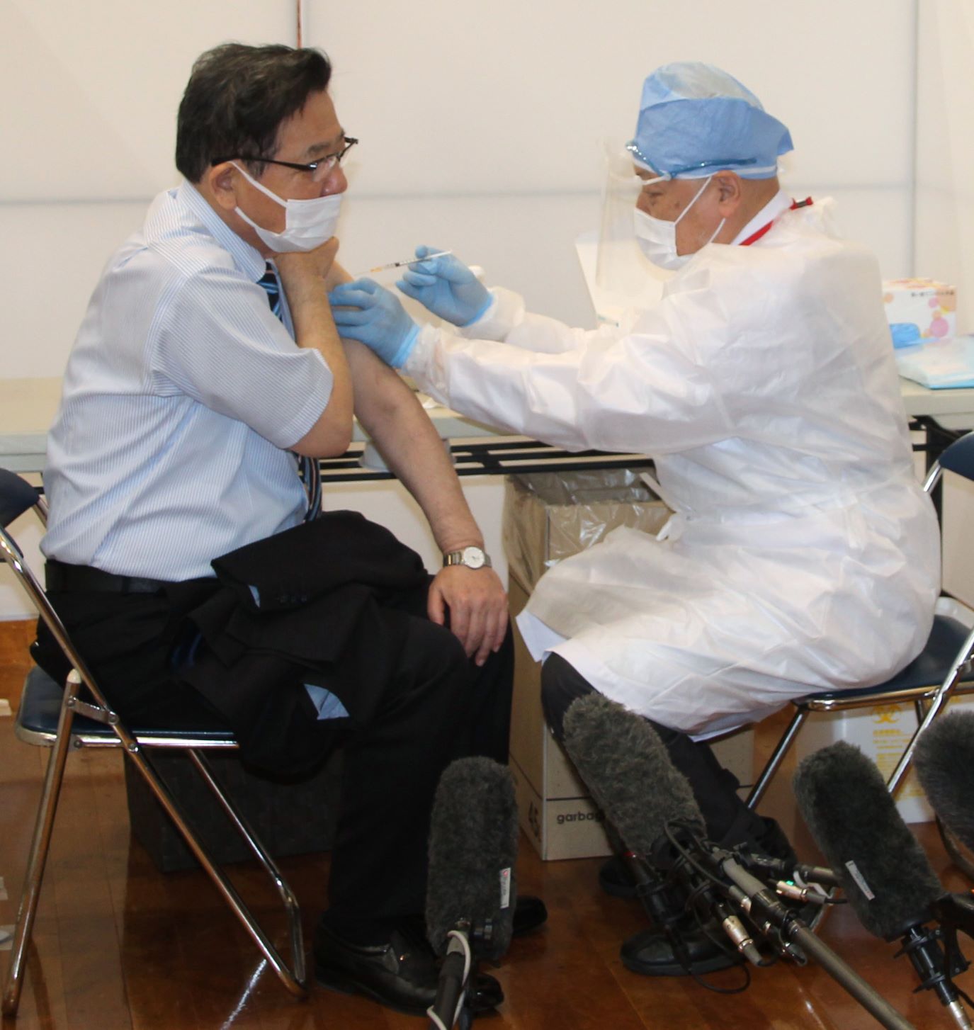 新型コロナウイルスワクチンの接種を受ける北九州市の北橋健治市長（左）＝2021年4月12日、同市小倉北区