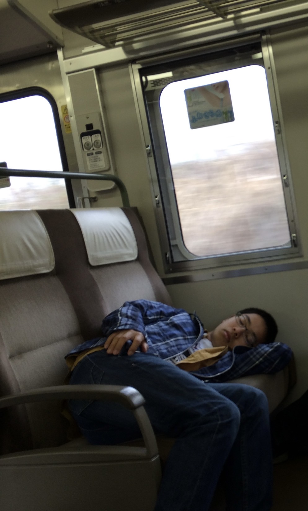 中学卒業後に友人と旅行した際の中原さん。電車移動が負担で横になって過ごしたという（同）