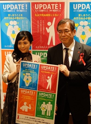 世界エイズデーを前に啓発用ポスターを手にする白阪琢磨エイズ予防財団理事長（右）【時事】
