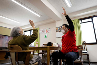東京のデイケア施設で、体操をする高齢の女性（左）（ＡＦＰ時事）（資料）