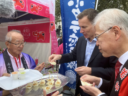 １日、ロンドンで催された「ジャパン祭り」で、日本産のホタテを試食するハント英財務相（右から２人目）と林肇駐英大使（右端）

