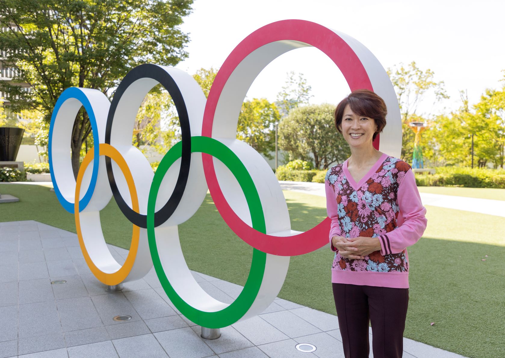 オリンピックシンボル前に立つ有森裕子さん