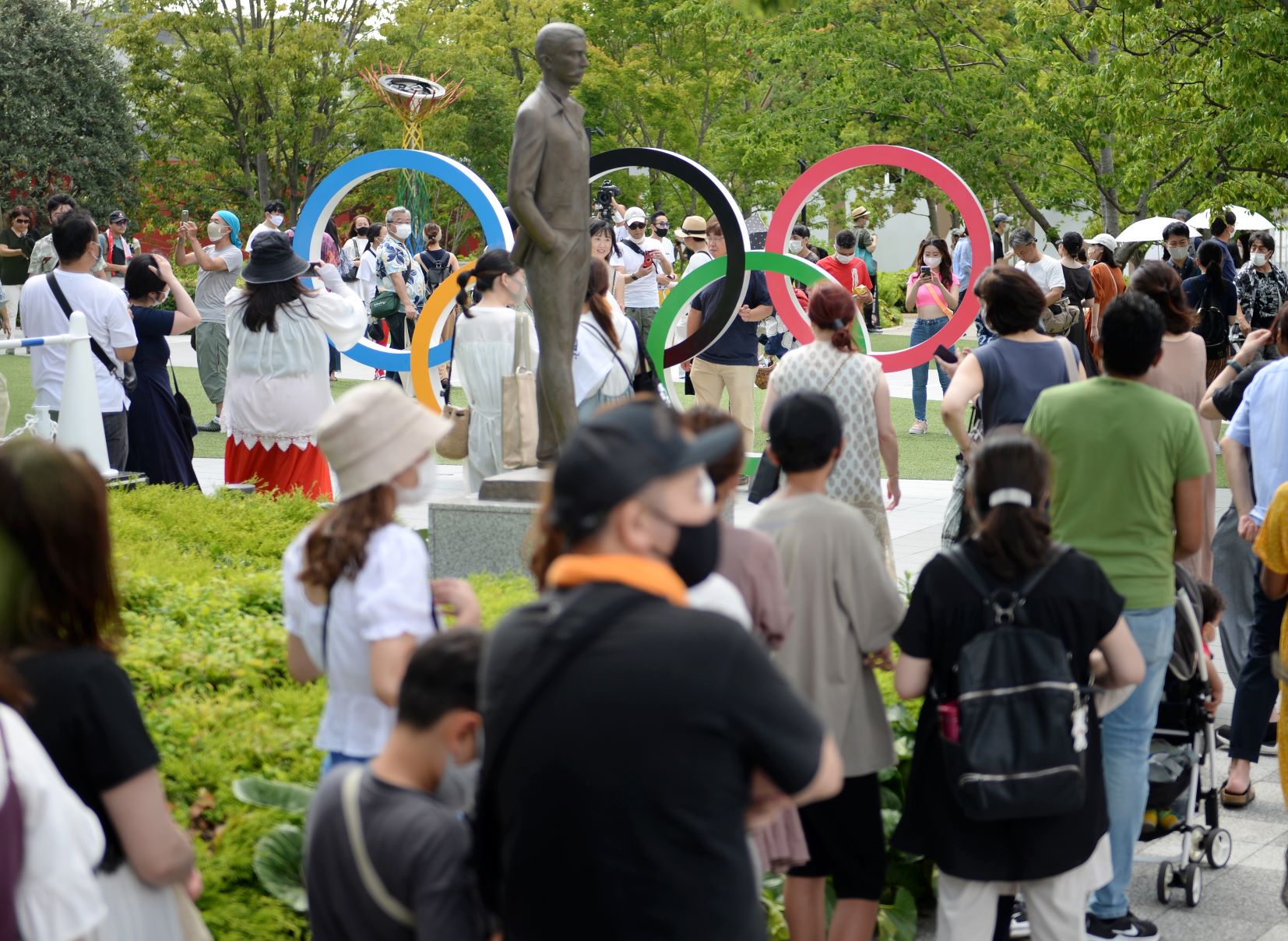 五輪マークと記念撮影をするため集まった人たち＝東京都新宿区　2021年07月31日