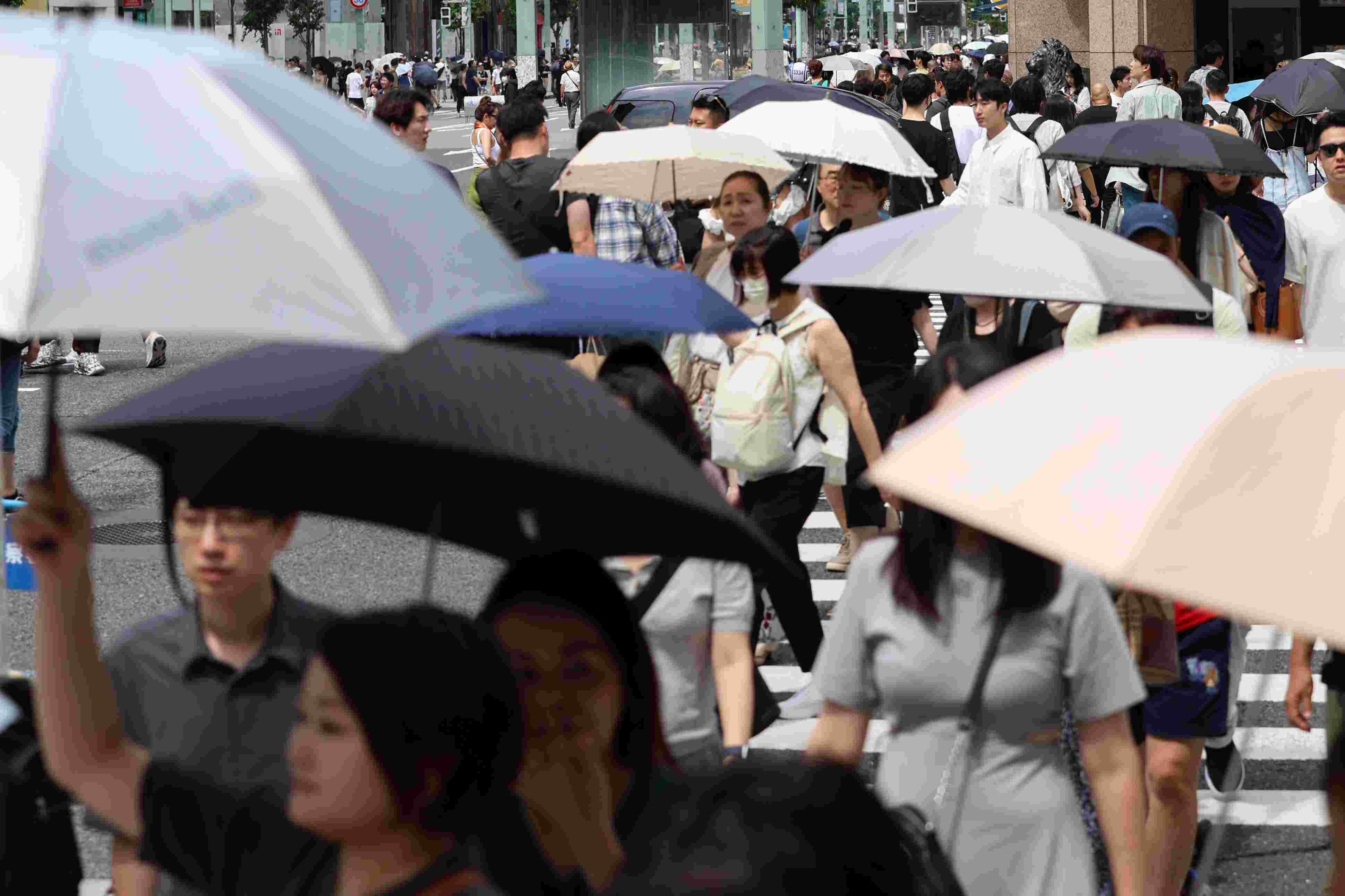 猛暑の中、日傘を差して歩く人たちの中にマスク姿も＝７月、東京・銀座