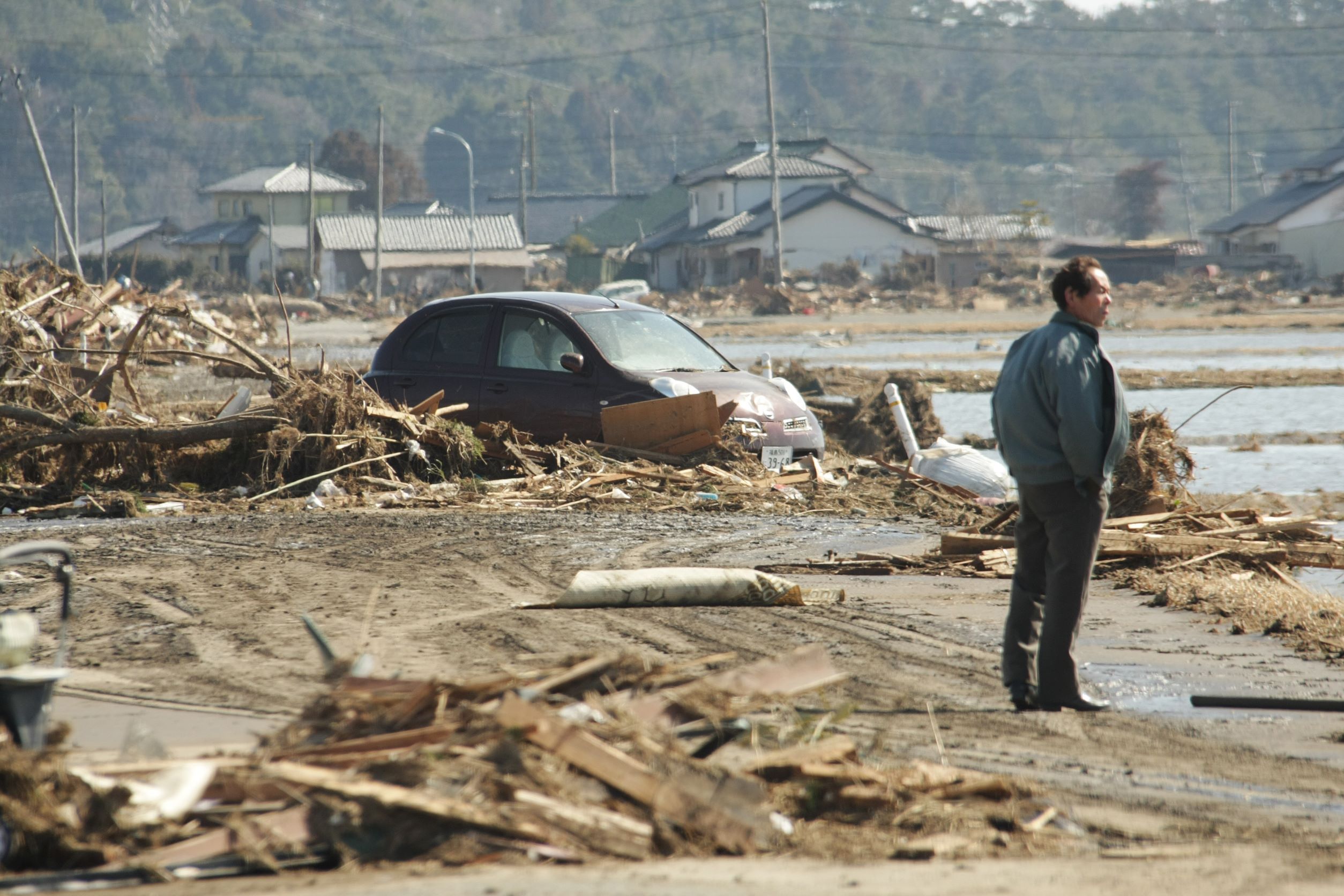 津波が押し寄せた福島県南相馬市でぼうぜんと立ち尽くす男性＝２０１１年３月１２日【時事通信社】