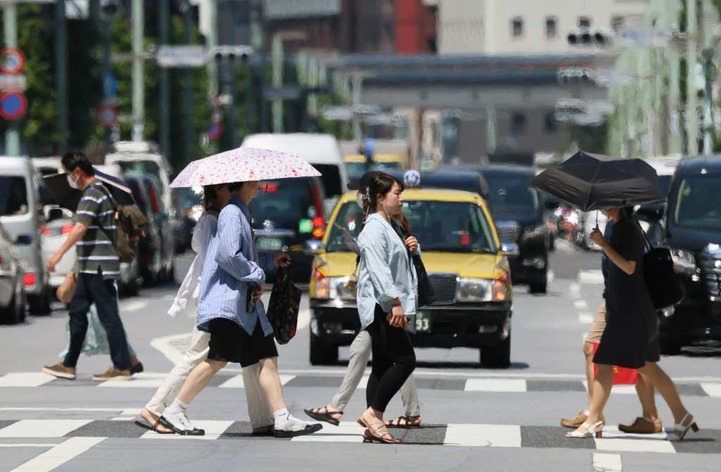 猛烈な暑さの中、横断歩道を渡る人々＝東京・銀座