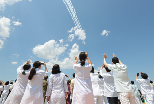 コロナ禍に奮闘する医師や看護師など、医療従事者に敬意と感謝の気持ちを示すために病院の上空を通過する航空自衛隊・曲技飛行チーム「ブルーインパルス」。あれから２年近くがたった＝2020年5月29日、東京都世田谷区（本文と直接関係はありません）【時事通信社】