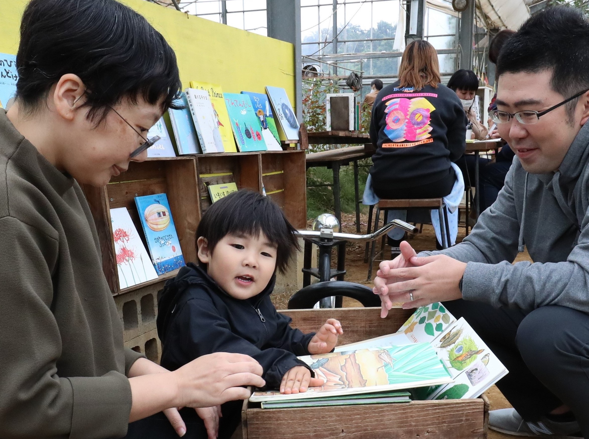 観光農園のビニールハウス内に絵本がずらり。読み聞かせを楽しむ親子（２０２０年１０月１７日撮影、神奈川県平塚市で）