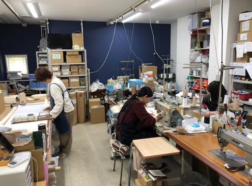 ミムロの作業場の様子。本縫いミシンを使って縫製したり(右)、エンドカッターの裁断台でそけいベルトを検品したりしている