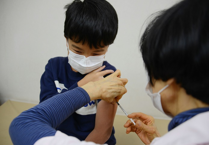 インフルエンザの予防接種を受ける小学生＝千葉県松戸市、2018年12月26日【時事】