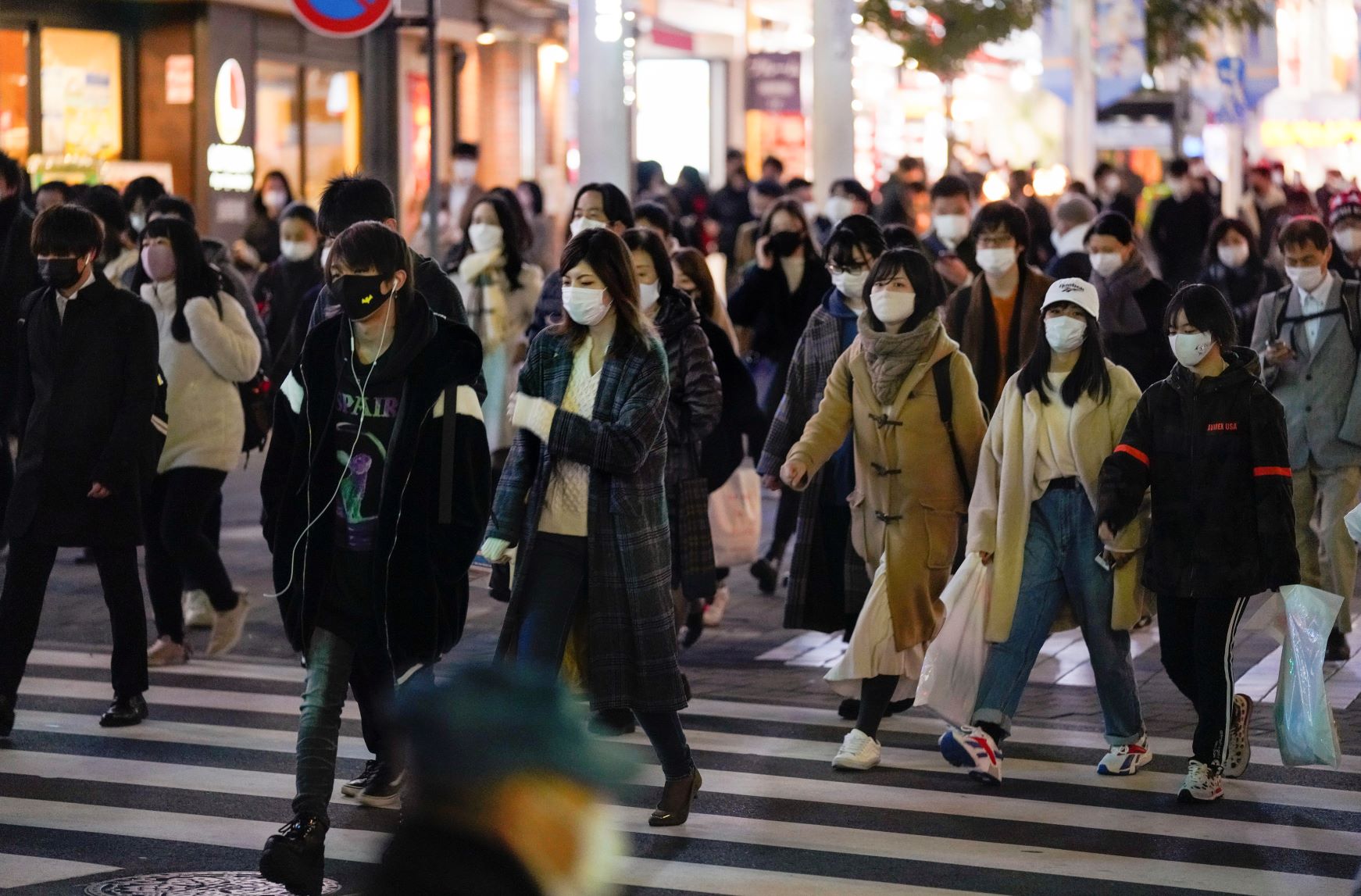 クリスマスイブの夜、マスクをつけた人が行き交う池袋＝１２月２４日、東京・池袋【EPA時事】