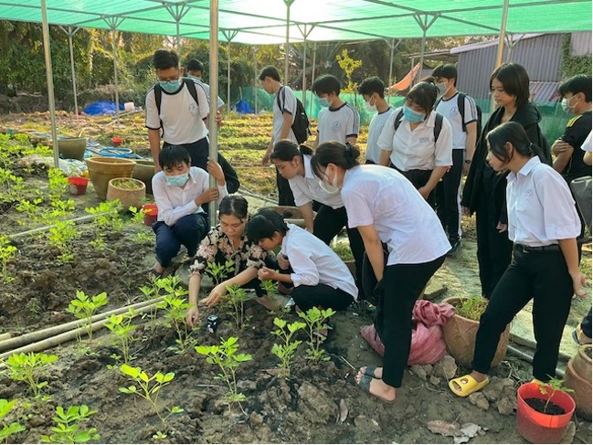 学校菜園で病害虫の状況を調べる高校生たち