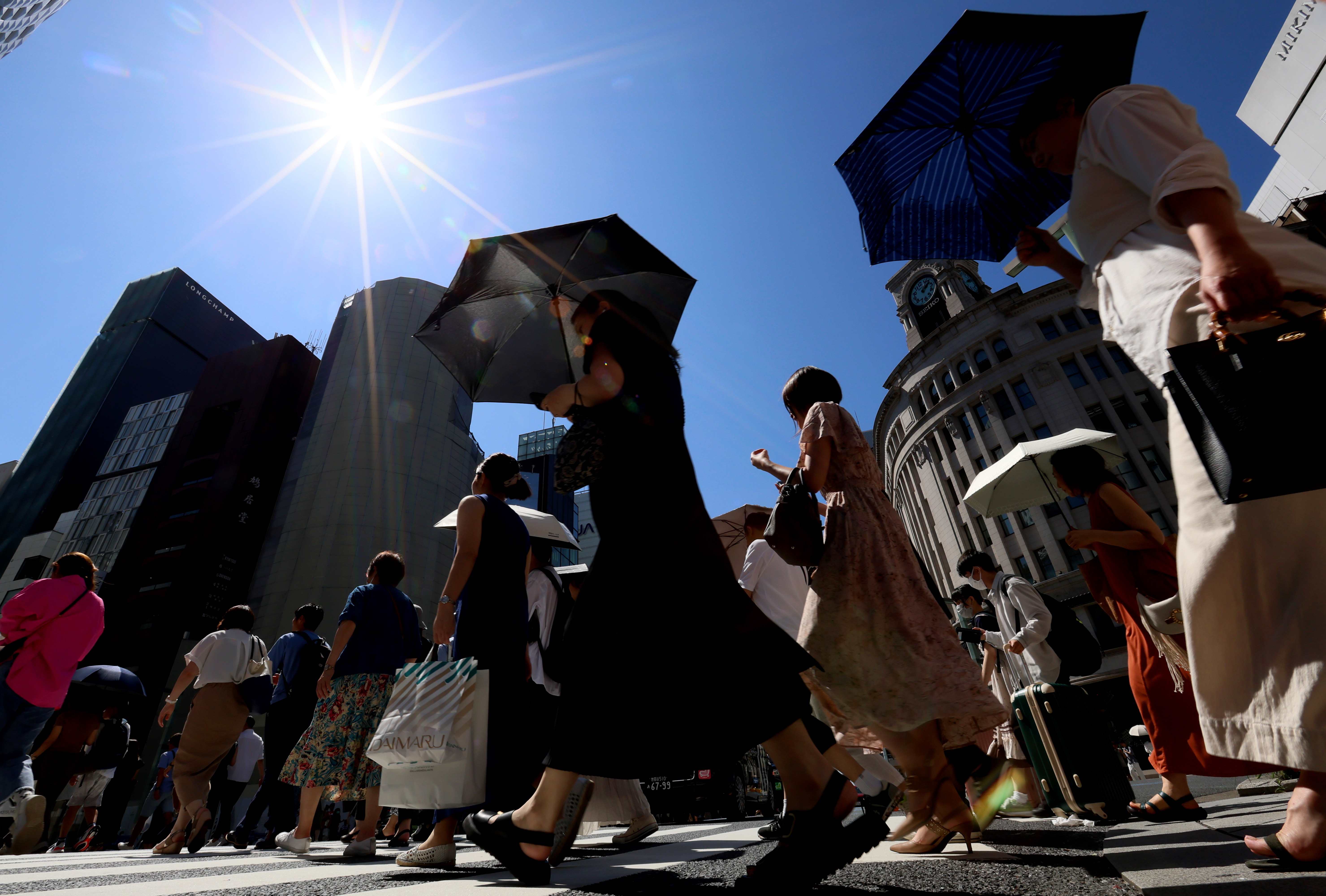 猛暑の中、日傘を差して歩く人たち（2023年7月、東京・銀座）