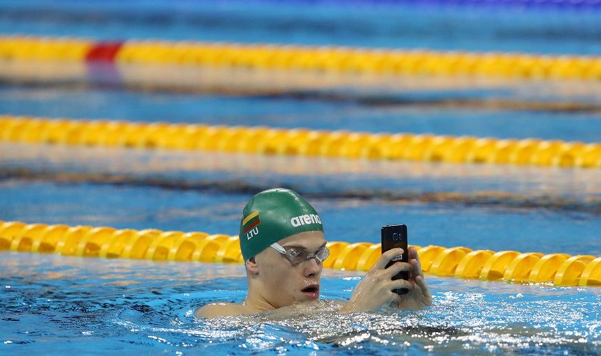 上司からメール？ 写真はスマートフォンを手に練習するルーマニアの競泳選手＝2016年7月31日、ブラジル・リオデジャネイロ（時事通信社）