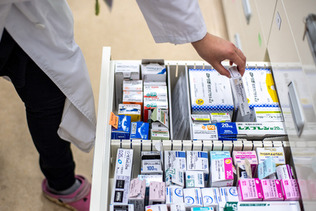 緊急避妊薬（アフターピル）を薬局の引き出しから取り出す薬剤師＝２０２２年６月、東京都内（ＡＦＰ時事）