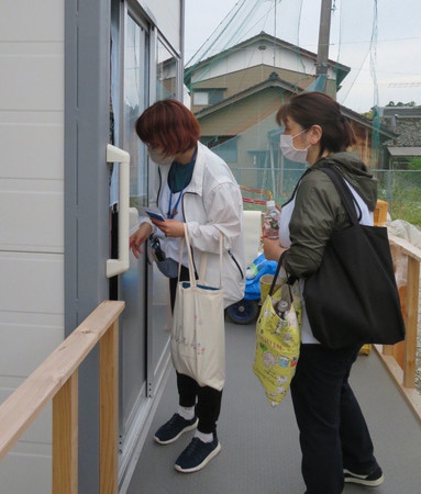 水を配布しながら仮設住宅を巡回する石川県珠洲市の社会福祉協議会の職員ら＝１８日、同市