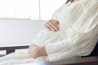室内でくつろぐ妊婦(写真はイメージ)