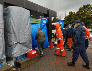 石川県輪島市の避難所に設置されたシャワーブースに入る住民（左）（資料写真）