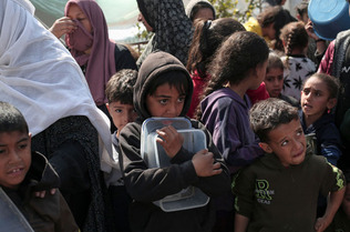 ２８日、パレスチナ自治区ガザ南部のラファで食料を求めて集まる子供ら（ＡＦＰ時事）