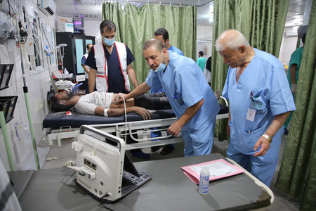 急患の治療に当たるパレスチナ自治区ガザ中部ヌセイラットの病院の医師ら＝２４日
