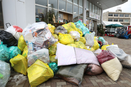 避難所前に積み上げられたごみ＝１０日、石川県珠洲市

