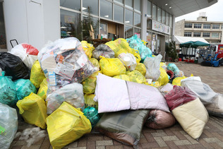 避難所前に積み上げられたごみ＝１０日、石川県珠洲市
