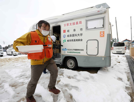 医薬品を供給する車両「モバイルファーマシー」から薬を運ぶ薬剤師＝８日、石川県珠洲市
