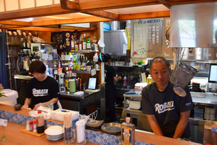 能登半島地震の被災地で炉端焼き店を営む浅井誠さん（右）＝８月２８日、石川県珠洲市
