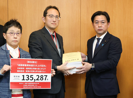 全国がん患者団体連合会などの関係者から署名を受け取る福岡資麿厚生労働相（右）ら＝１２日午後、東京都千代田区
