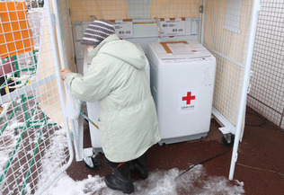 避難所の洗濯機を利用する女性＝２４日午後、石川県七尾市
