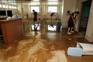 浸水した田主丸中央病院で清掃する職員ら＝１１日午後、福岡県久留米市
