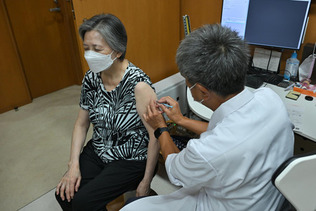 秋の新型コロナウイルスワクチン接種を受ける女性（左）＝２０日午前、東京都港区