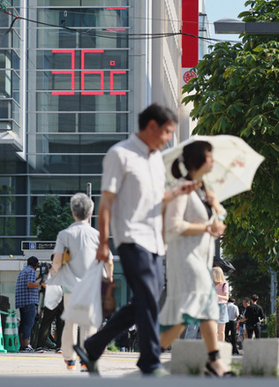 観測史上最高気温の３６・３度を記録した札幌市内を歩く人たち＝２３日午後、札幌市中央区