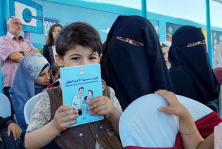 ６日、パレスチナ自治区ガザ南部のハンユニスで、母子手帳の本格導入から１５年を記念する式典に参加した親子