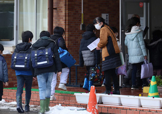 学校が再開し、登校する小中学生たち＝２４日午前、石川県輪島市