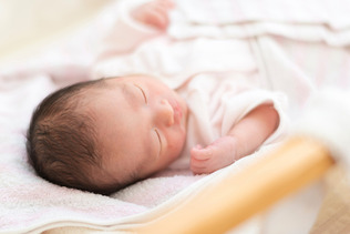 新生児室で眠る赤ちゃん（資料写真）