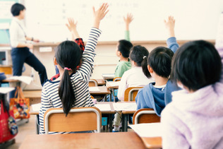 教室で手を上げる小学生（写真はイメージです。記事本文とは直接の関係はありません）