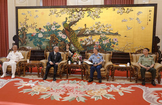 １７日、北京で会談する訪中団の柳田篤志団長（左端）と、中国軍の景建峰・統合参謀部副参謀長（右から２人目）ら（笹川平和財団提供・時事）
