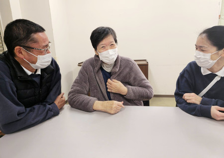 マスクを着けて談笑する介護老人保健施設「さくらがわ」の職員と利用者（中央）＝１１日、大阪市浪速区