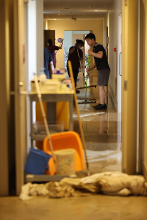 浸水した田主丸中央病院で清掃する職員ら＝１１日午後、福岡県久留米市