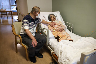 ５類移行で居室内での面会が可能となり、介護老人保健施設に入居する母（右）と会話する菅根圭也さん＝６日午後、東京都三鷹市