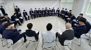 刑務官の前で自身の体験を話す「かがやきホーム」研修員の男性(手前中央)=1月22日、堺市