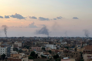 スーダン軍と準軍事組織「即応支援部隊(RSF)」との内戦で、空爆により煙が上がる首都ハルツーム=2024年10月(AFP時事)