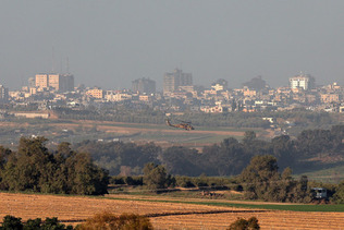 １２日、パレスチナ自治区ガザ中部マガジとの境界付近を飛ぶイスラエル軍のヘリコプター（ＥＰＡ時事）